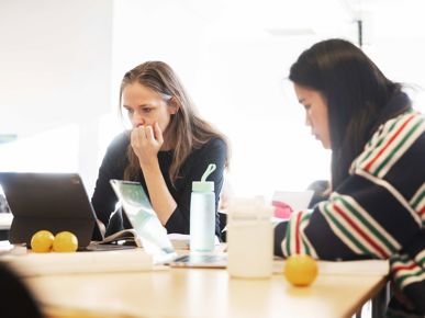 To elever arbejder koncentreret på computer i klasselokalet.